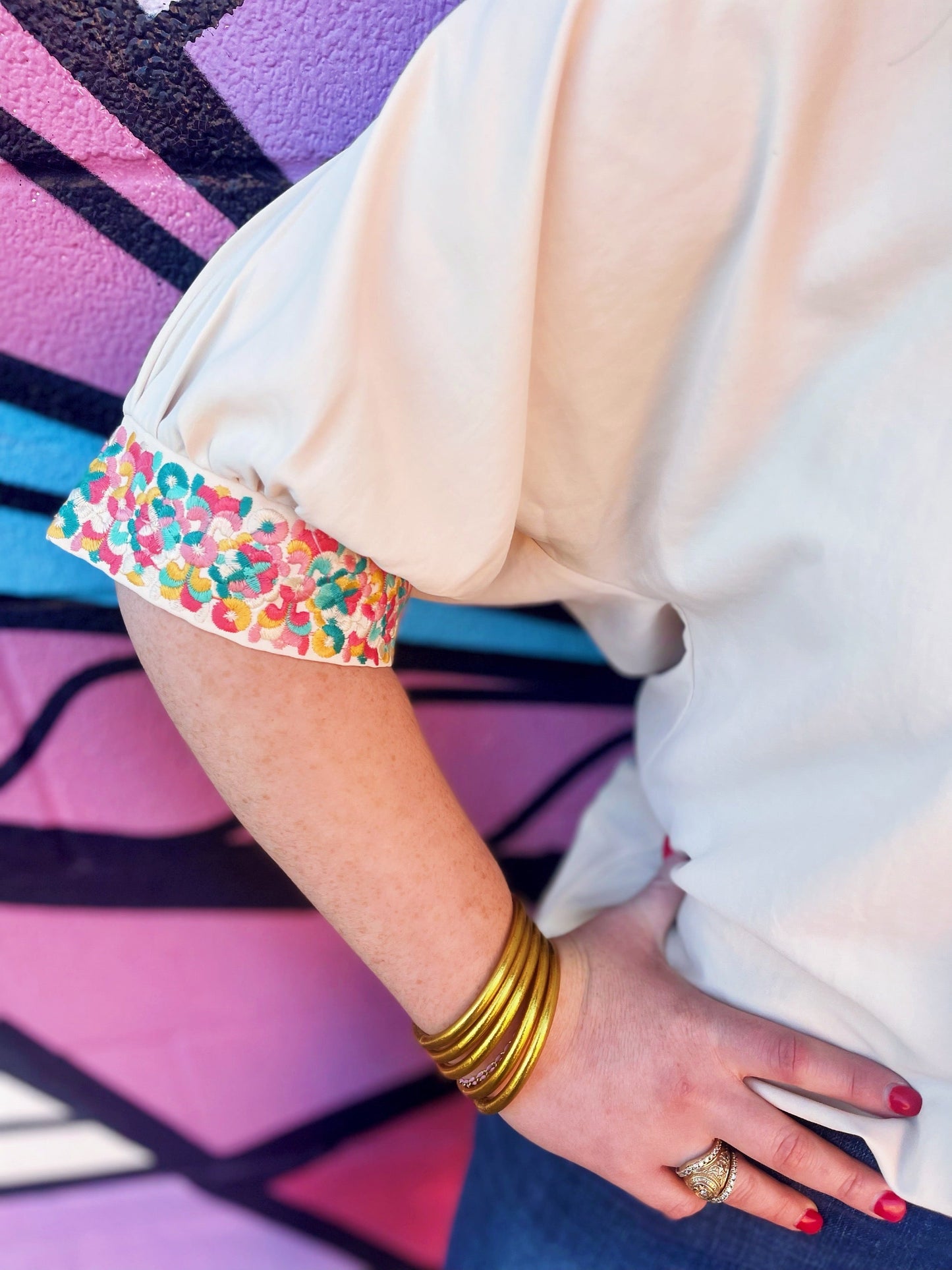 The Carlee Top by Washco Apparel is fun, unique and can be styled so many ways! We love the pop of beautiful embroidery design on the beige sleeves and that it is an oversized button down top with small slits on the sides.