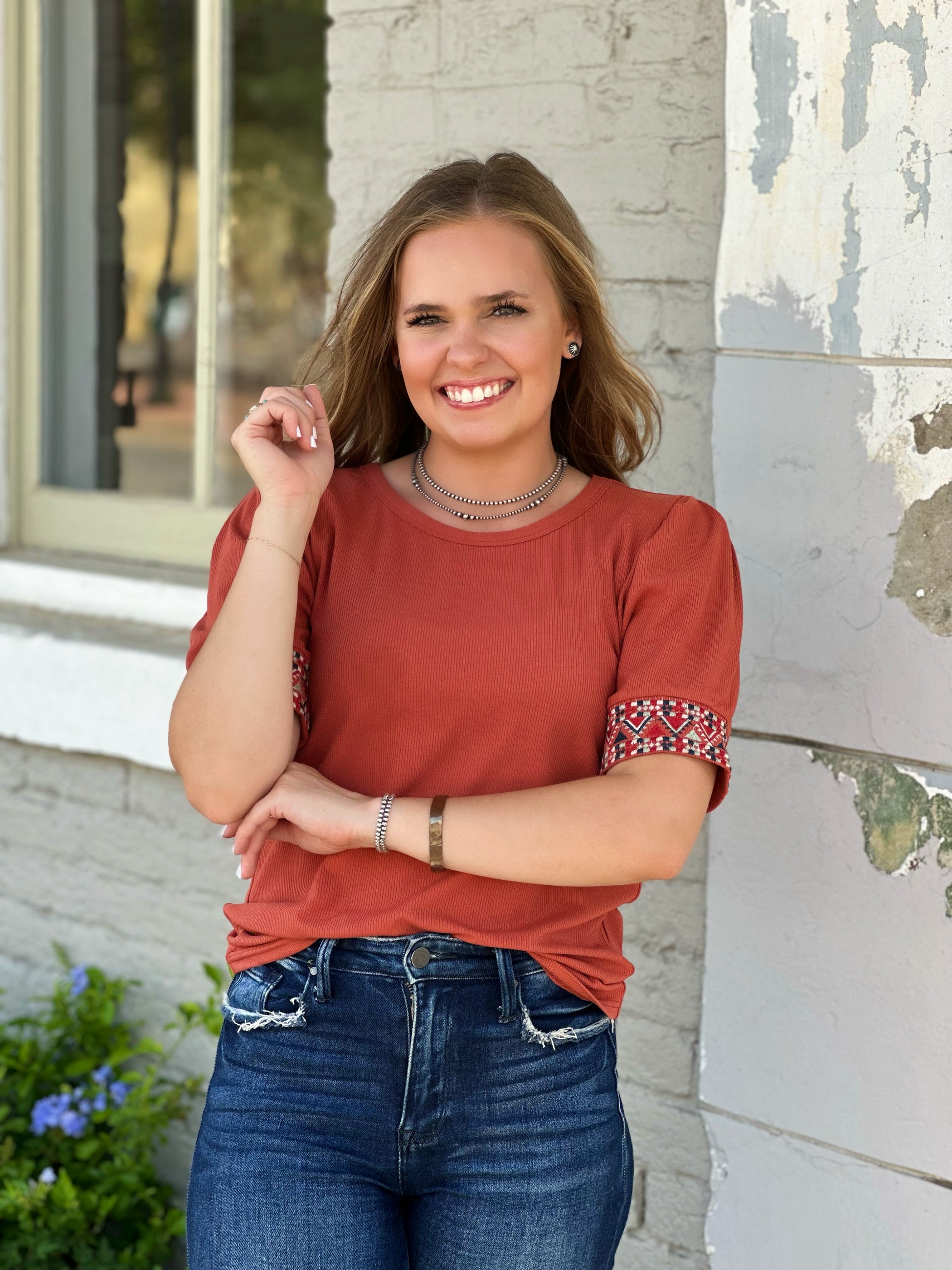 The Cheyenne Top by Washco Apparel is a top seller! This beautiful rust top is a great transitional piece and we love the aztec embroidery design around the sleeves.