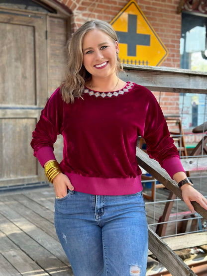 The Danielle Top by Washco Apparel is a burgundy velvet mid cropped sweater with colorful aztec embroidery design around the neckline! It is very soft and comfortable & great for holiday events.