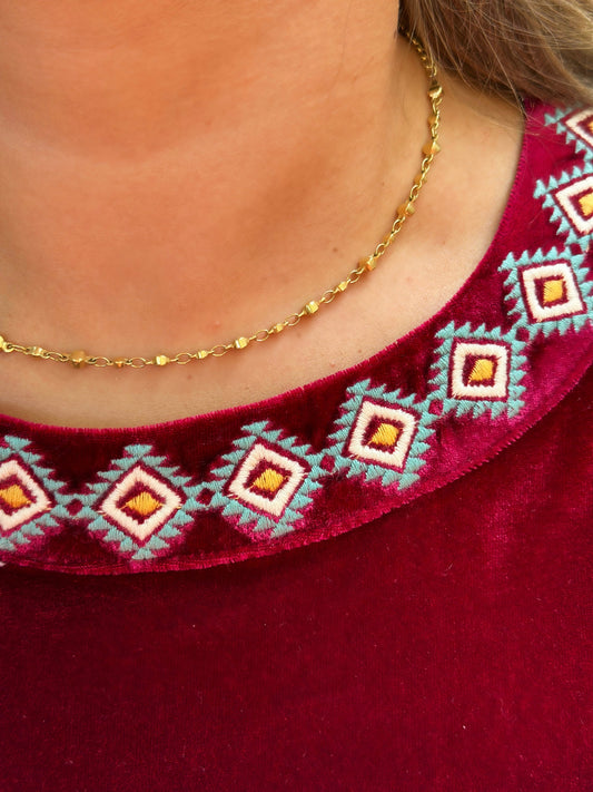 The Danielle Top by Washco Apparel is a burgundy velvet mid cropped sweater with colorful aztec embroidery design around the neckline! It is very soft and comfortable & great for holiday events.