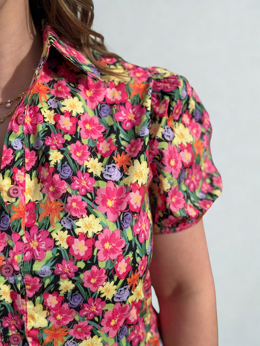 Colorful floral patterned shirt worn by a person on a plain background