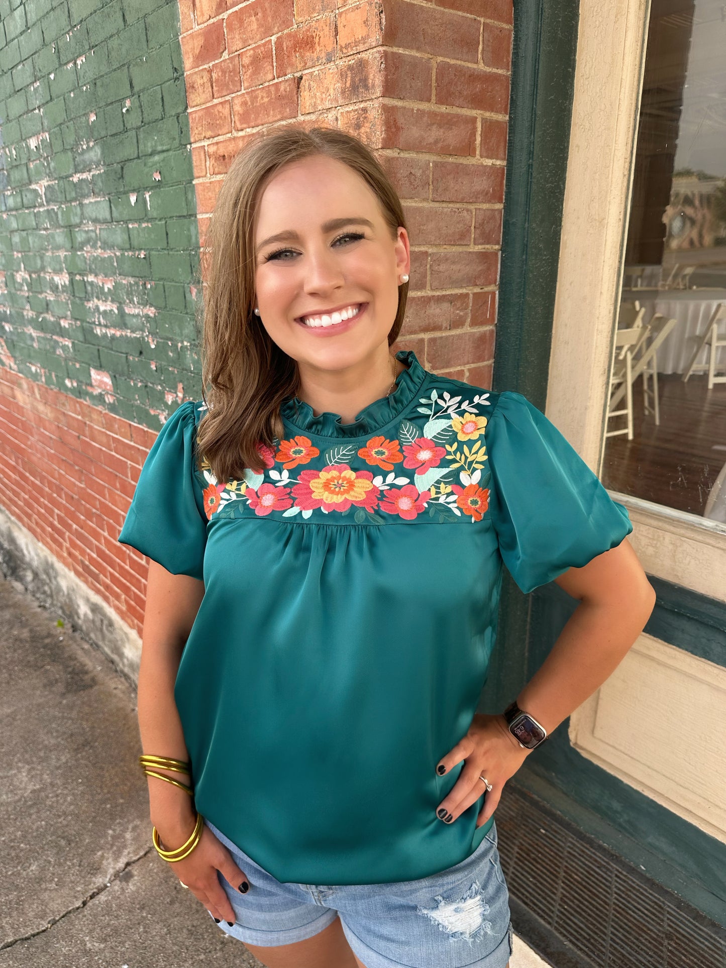 The Amanda top by Washco Apparel is a great top for work and play. The top includes beautiful floral embroidery detail and puffed sleeves.