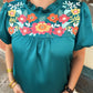 The Amanda top by Washco Apparel is a great top for work and play. The top includes beautiful floral embroidery detail and puffed sleeves.