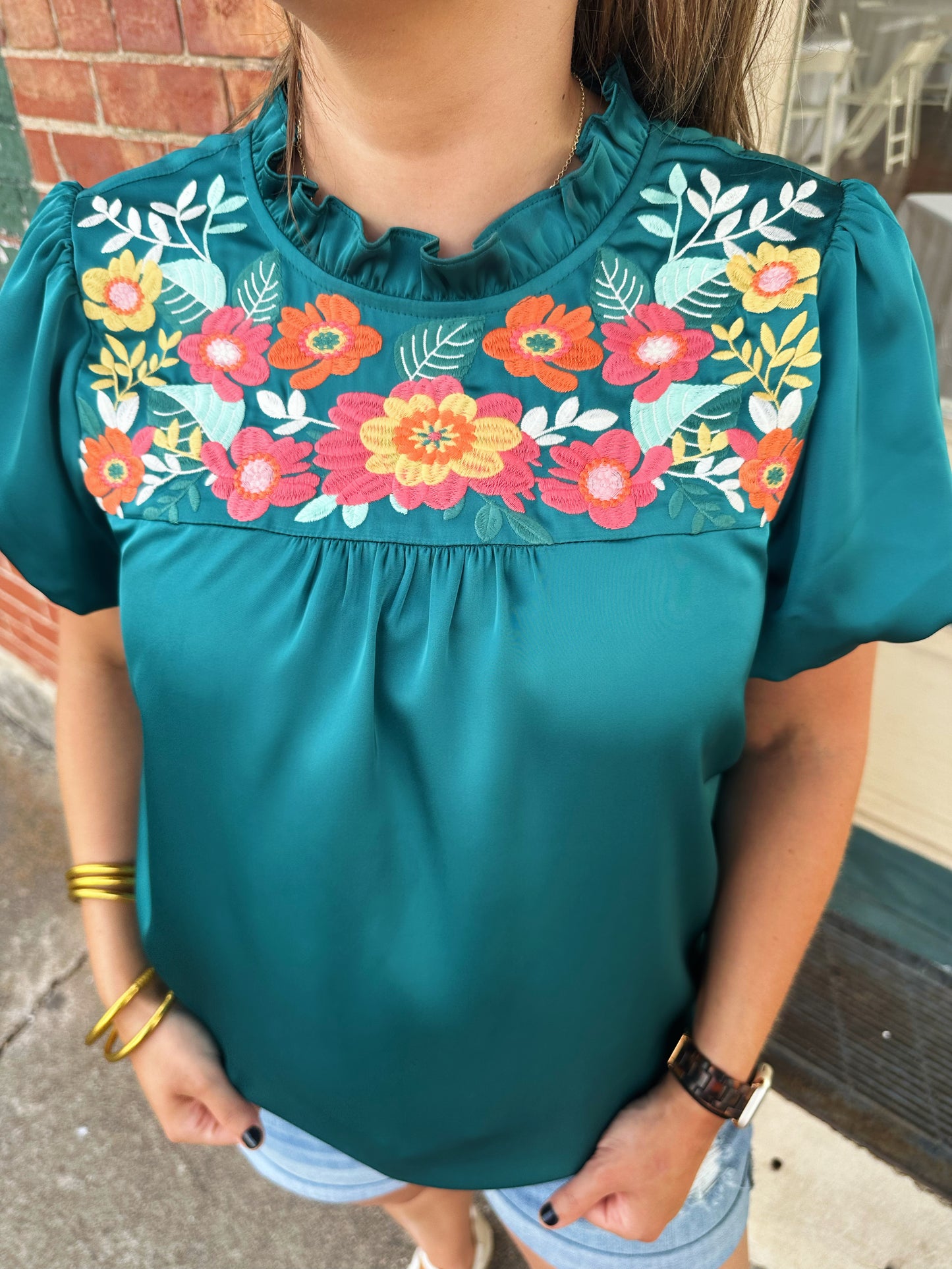 The Amanda top by Washco Apparel is a great top for work and play. The top includes beautiful floral embroidery detail and puffed sleeves.