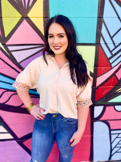 The Carlee Top by Washco Apparel is fun, unique and can be styled so many ways! We love the pop of beautiful embroidery design on the beige sleeves and that it is an oversized button down top with small slits on the sides.