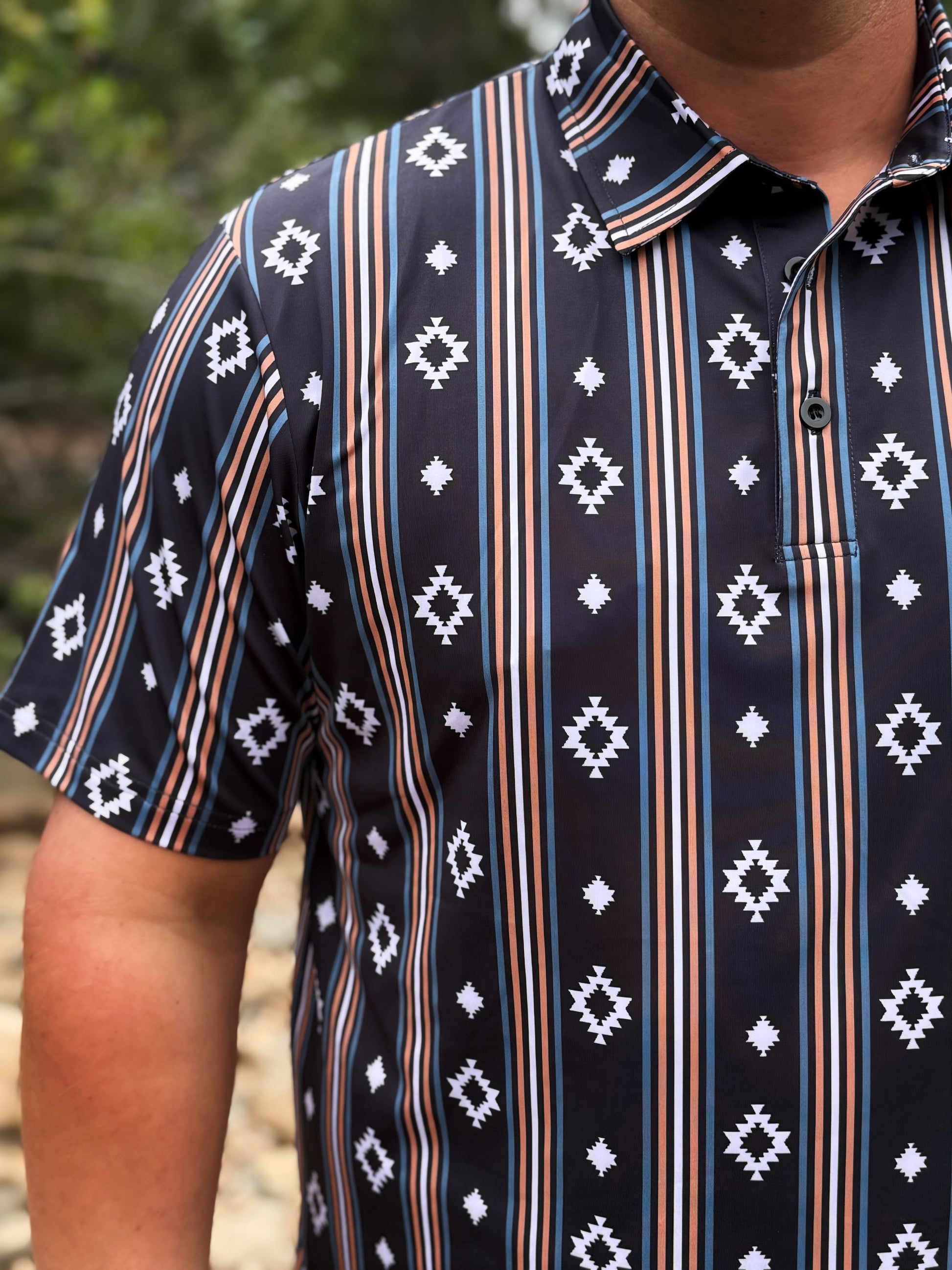 Person wearing a patterned shirt with vertical stripes and geometric designs.